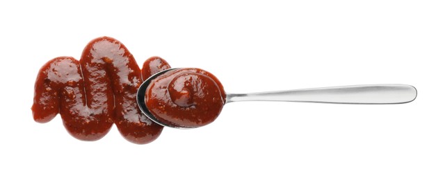 Photo of Tasty barbecue sauce and spoon isolated on white, top view