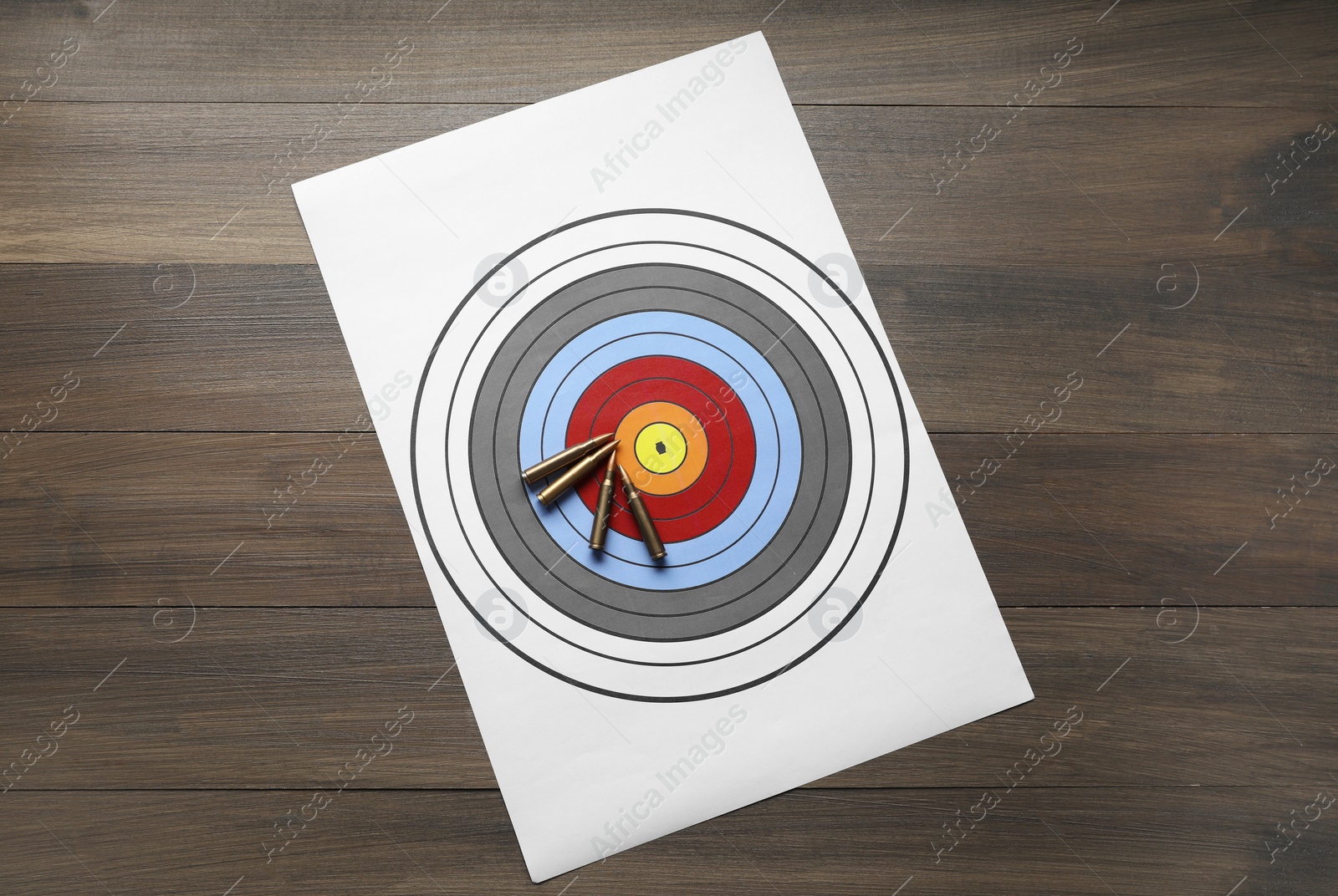 Photo of Shooting target and bullets on wooden table, top view
