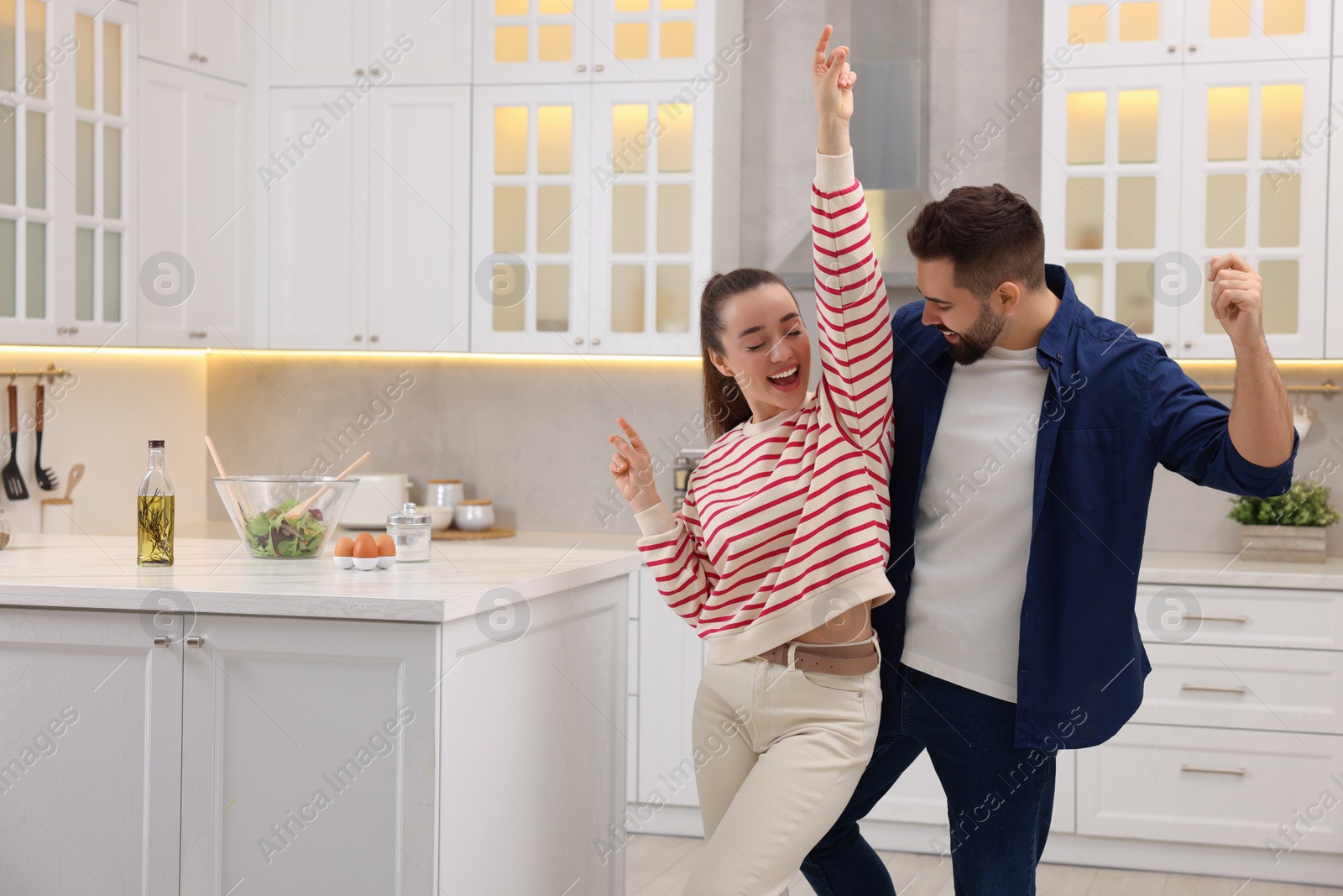 Photo of Happy lovely couple dancing together in kitchen