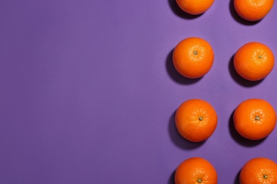 Photo of Flat lay composition with fresh ripe oranges on purple background. Space for text