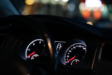 Photo of Closeup view of dashboard with speedometer and tachometer in modern car