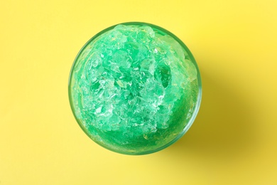 Photo of Shaving ice in glass dessert bowl on yellow  background, top view