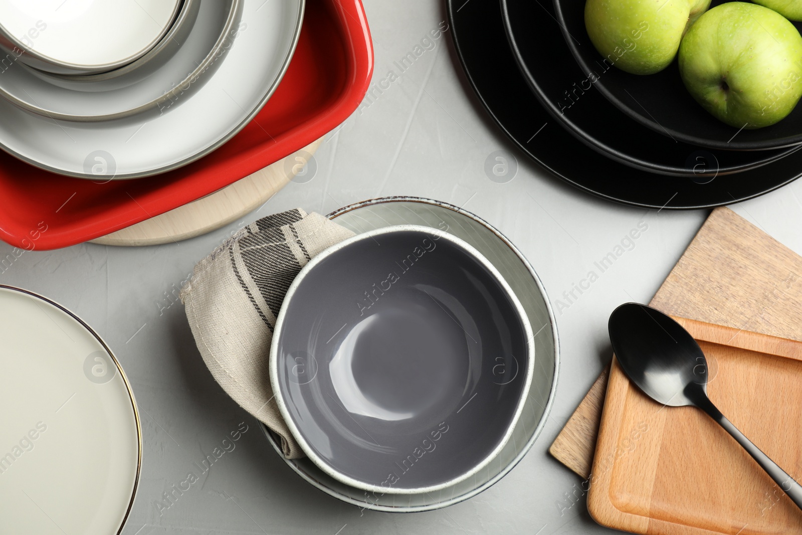 Photo of Set of clean dishware and apples on grey table, flat lay