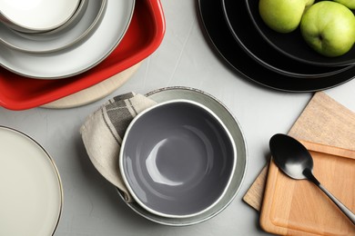 Set of clean dishware and apples on grey table, flat lay