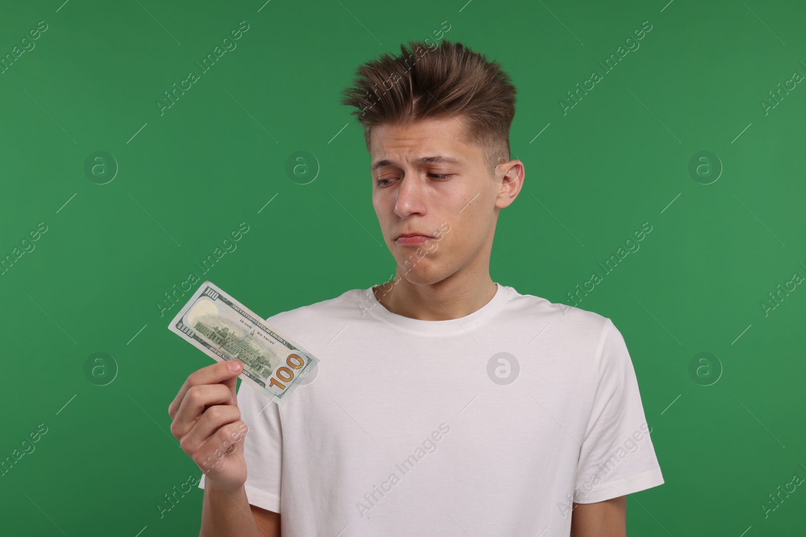 Photo of Upset man with dollar banknote on green background