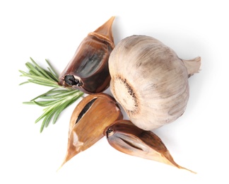 Photo of Aged black garlic with rosemary on white background, view from above
