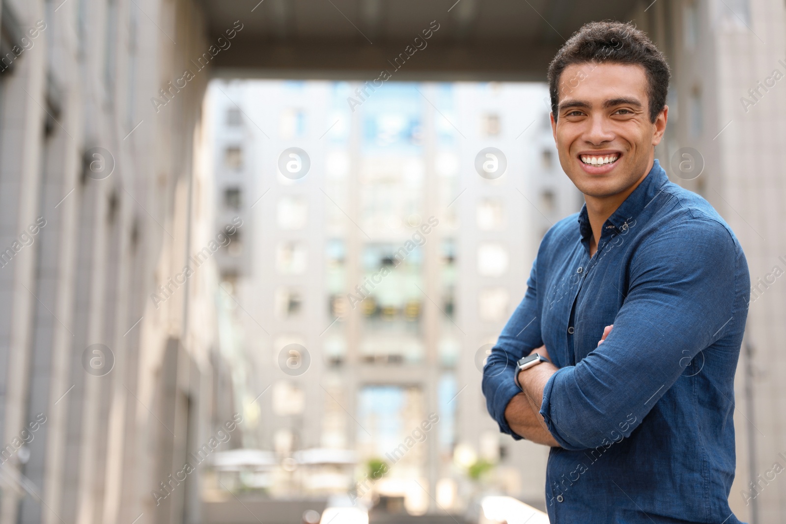 Photo of Portrait of handsome young African-American man on city street. Space for text