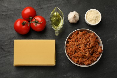 Photo of Flat lay composition with products for cooking lasagna on dark textured table