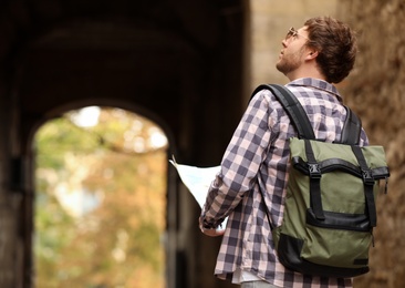 Photo of Traveler with backpack on city street, back view