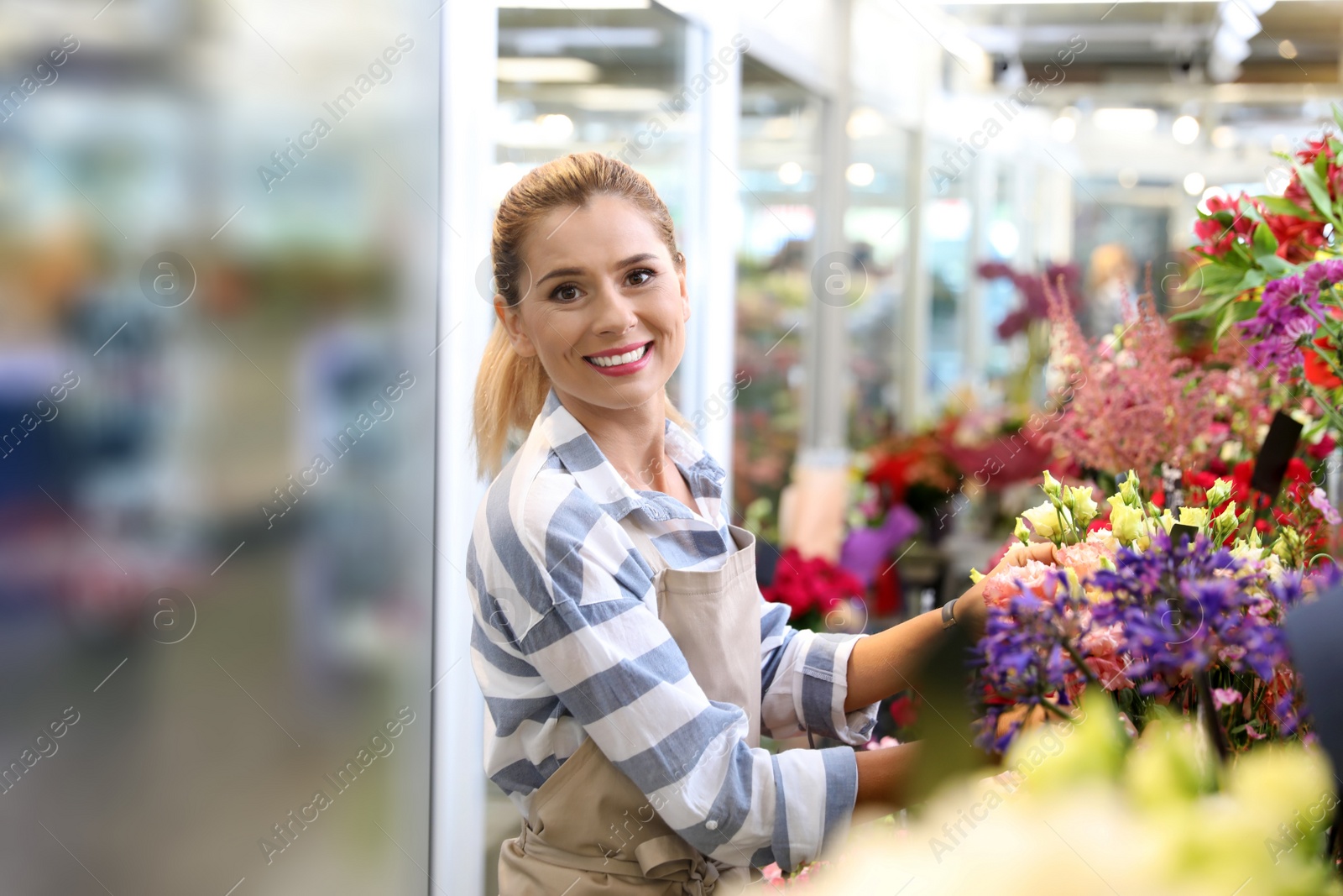 Photo of Beautiful female florist working in flower shop