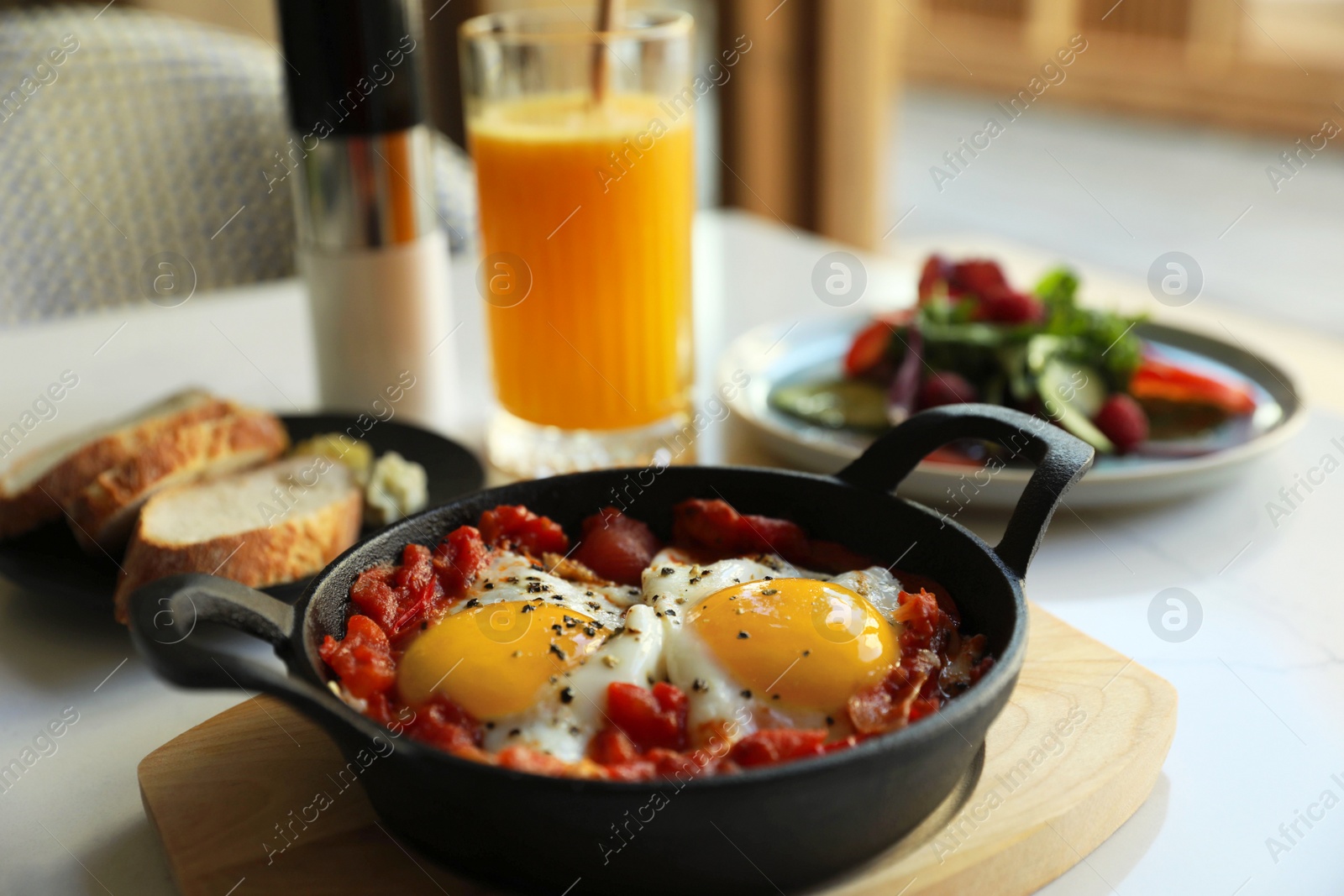 Photo of Tasty Shakshouka served on white table indoors. Traditional Arabic dish