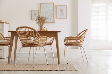 Dining room interior with wooden table and wicker chairs