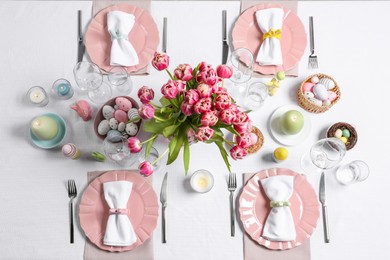 Festive table setting with beautiful flowers, flat lay. Easter celebration