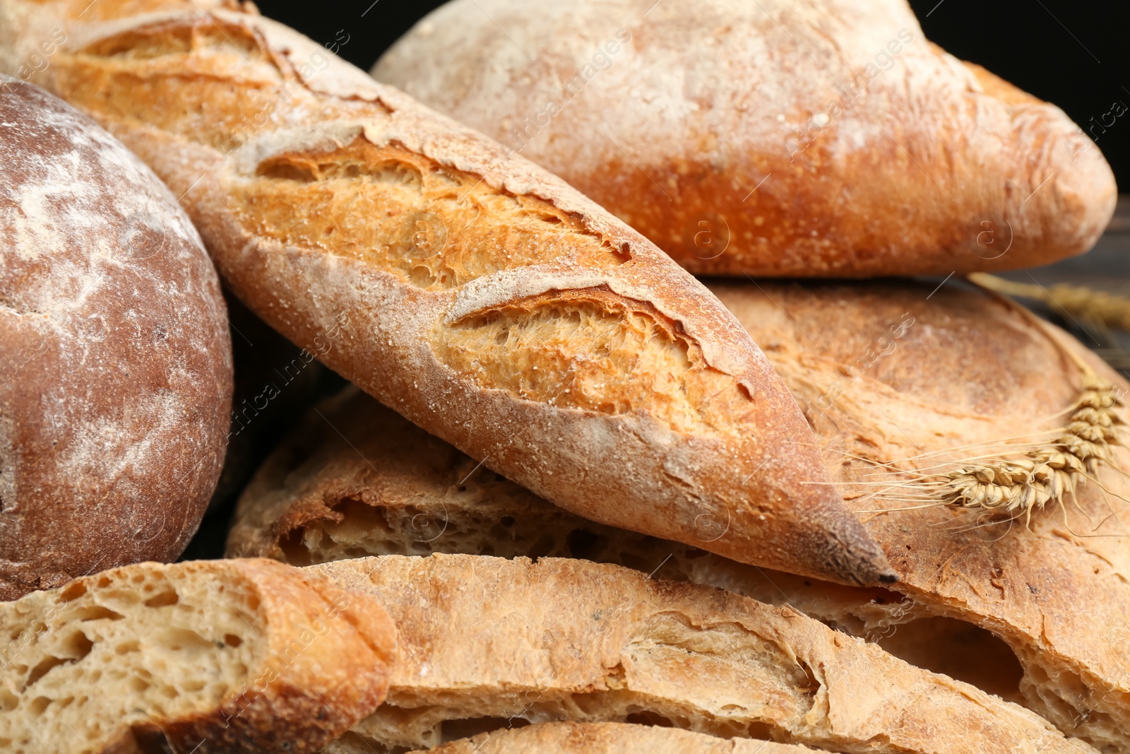 Photo of Different kinds of fresh bread as background, closeup