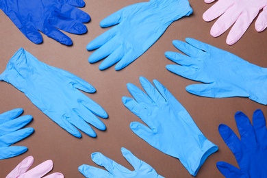 Photo of Flat lay composition with different medical gloves on color background