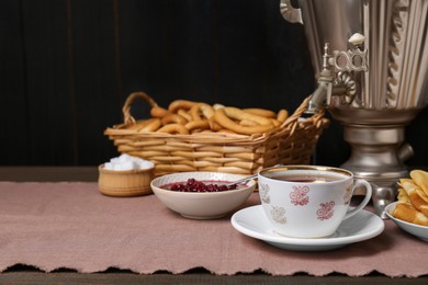 Photo of Aromatic tea, traditional Russian samovar and treats on table. Space for text