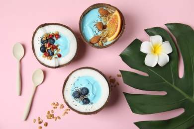 Flat lay composition with yummy spirulina smoothie in coconuts on color background