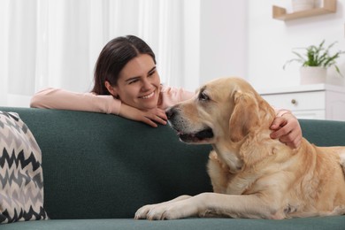 Photo of Happy woman with cute Labrador Retriever at home