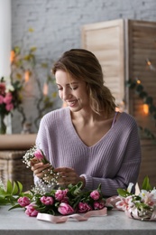 Female decorator creating beautiful bouquet at table