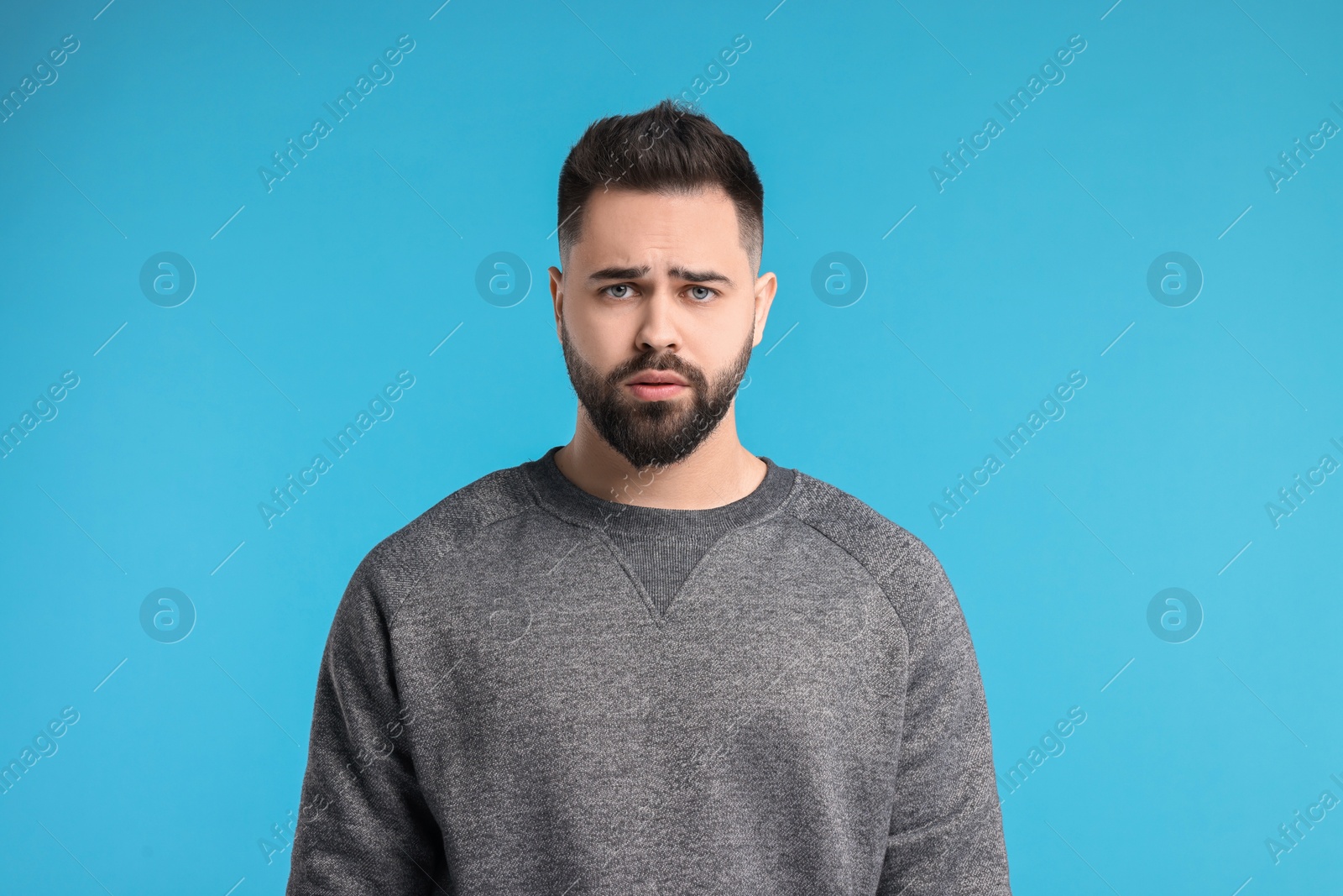 Photo of Portrait of sad man on light blue background