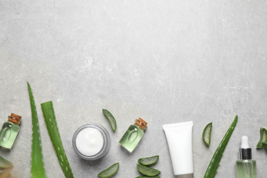 Photo of Flat lay composition with aloe vera and cosmetic products on grey background. Space for text