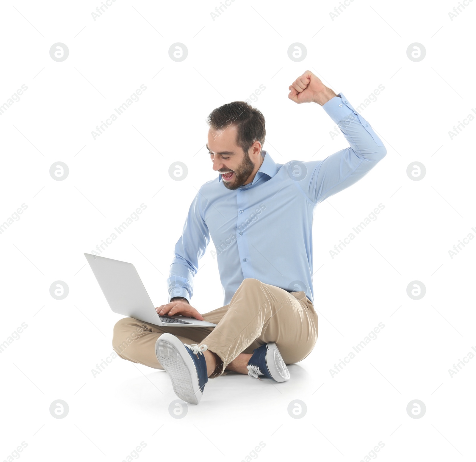 Photo of Emotional young man with laptop celebrating victory on white background