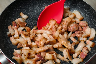 Cooking cracklings in frying pan, closeup. Pork lard