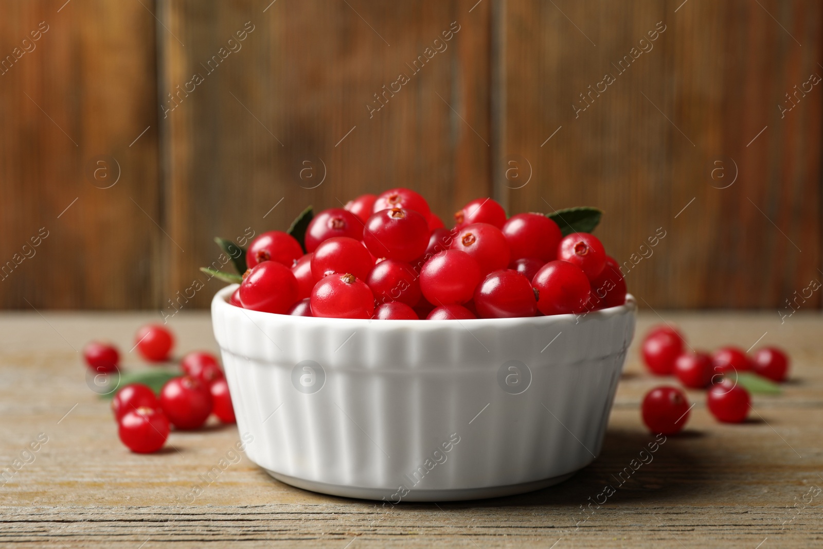 Photo of Tasty ripe cranberries on wooden table, closeup