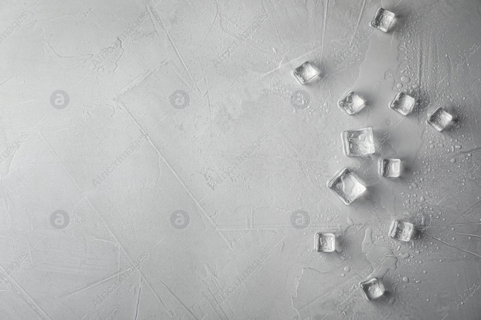 Photo of Crystal clear ice cubes with water drops on light grey table, flat lay. Space for text