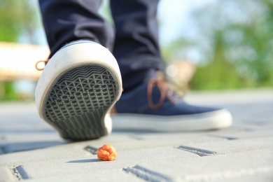 Man stepping in chewing gum on sidewalk. Concept of stickiness