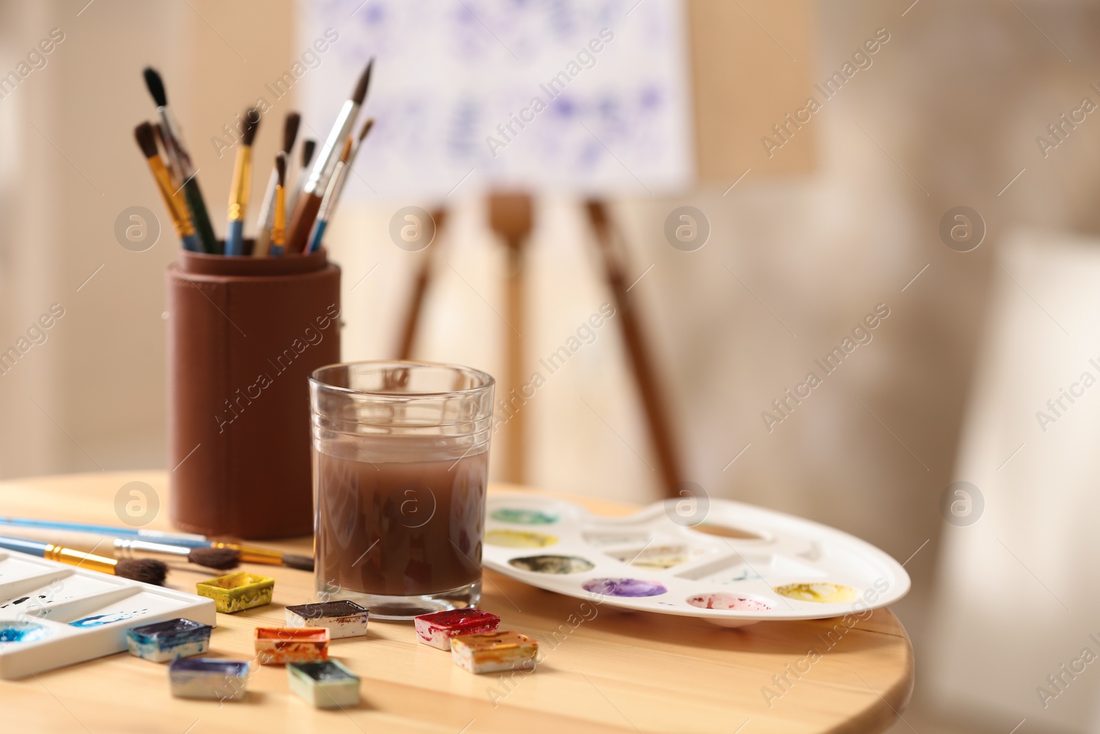 Photo of Composition with watercolor paints on wooden table in workshop