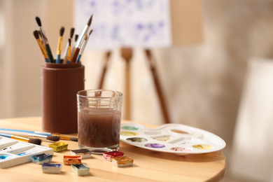 Composition with watercolor paints on wooden table in workshop