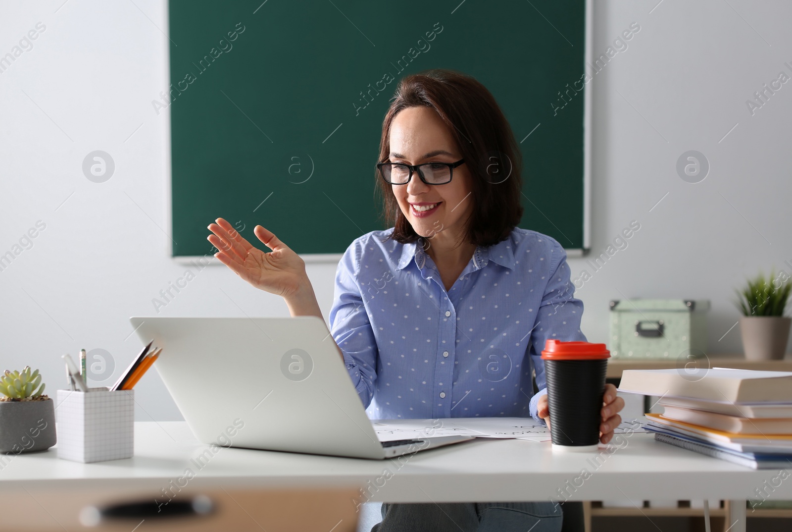 Photo of Teacher conducting online lesson in classroom during COVID-19 quarantine