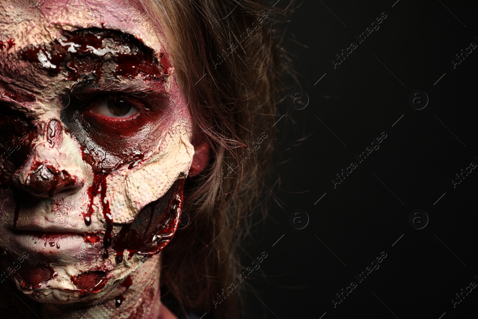 Photo of Scary zombie on dark background, closeup with space for text. Halloween monster