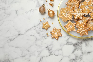 Photo of Tasty Christmas cookies and baubles on white marble table, flat lay. Space for text