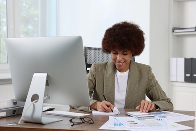 Professional accountant working at wooden desk in office