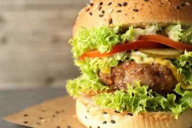 Photo of Burger with delicious patty on gray table, closeup. Space for text