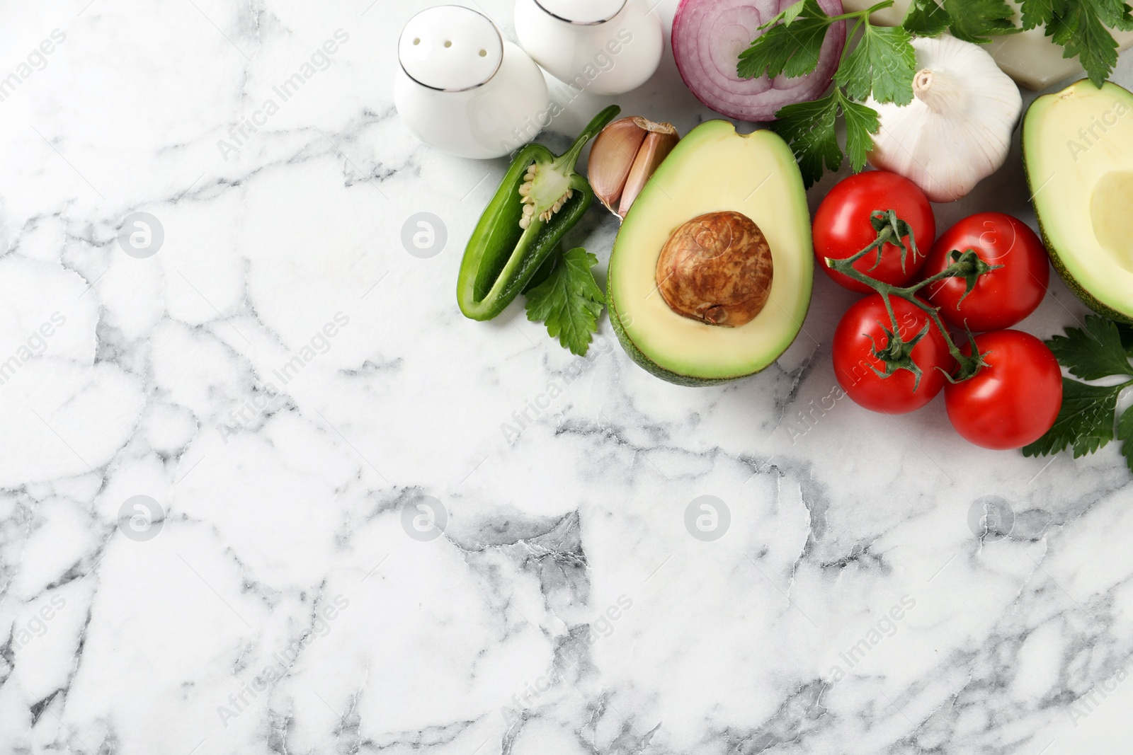 Photo of Fresh guacamole ingredients on white marble table, flat lay. Space for text