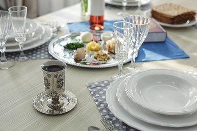Photo of Antique goblet and plates on table served for Passover (Pesach) Seder