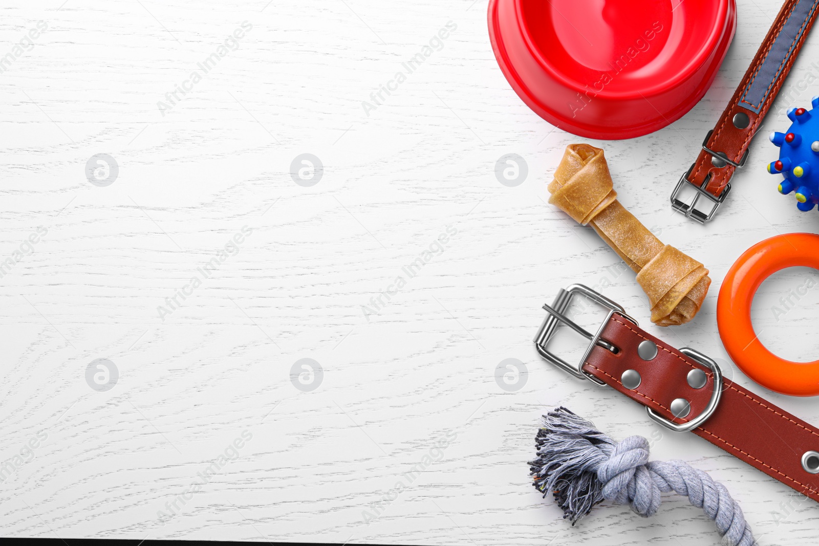 Photo of Flat lay composition with dog collars and different accessories on white wooden table, space for text