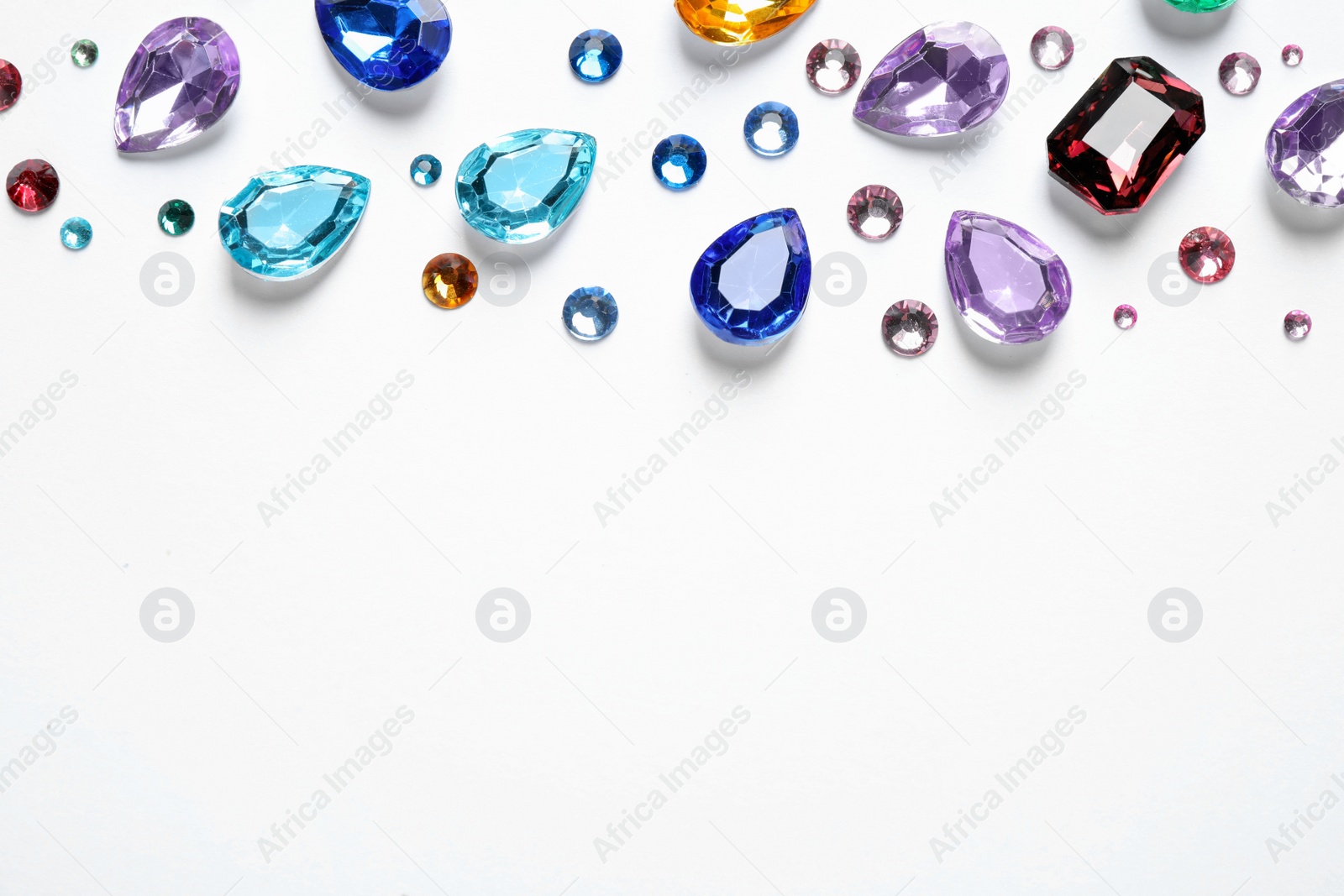 Photo of Different beautiful gemstones on white background, top view