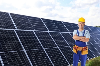 Image of Engineer near solar panels outdoors. Alternative energy source