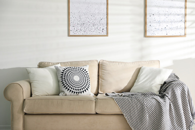 Photo of Stylish decorative pillows on beige couch indoors