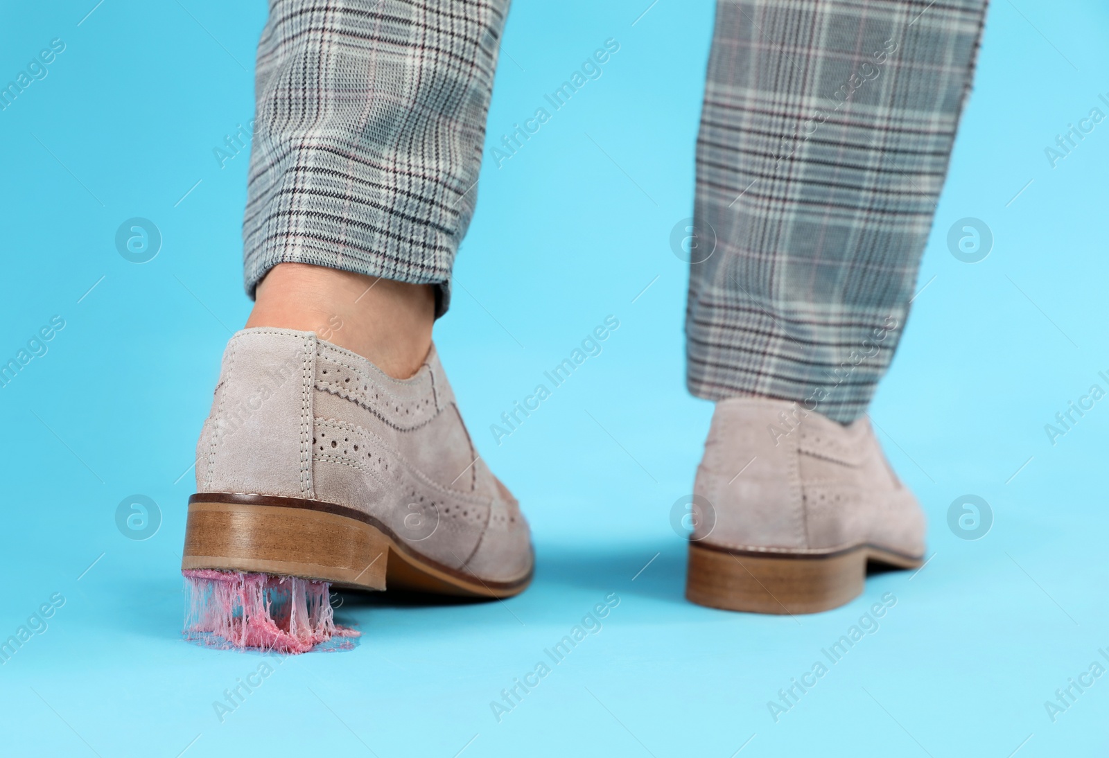 Photo of Person stepping into chewing gum on light blue background, closeup