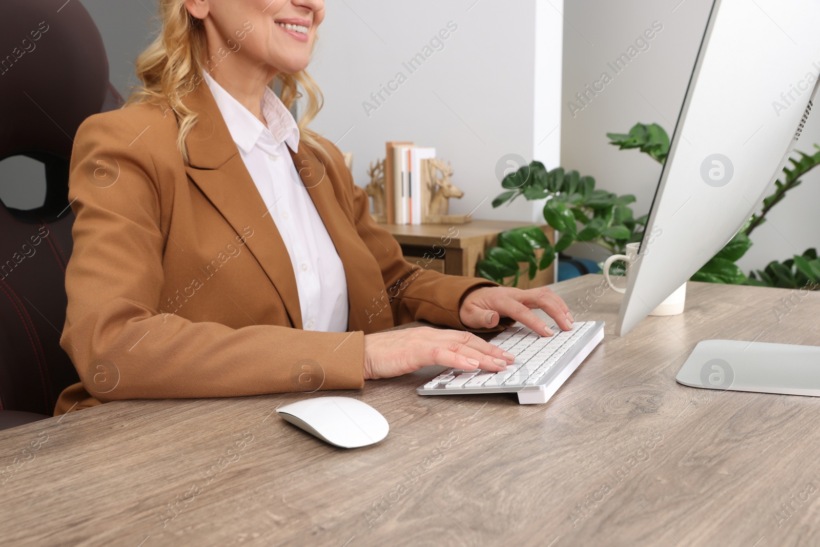 Photo of Lady boss working on computer at desk in office, closeup. Successful businesswoman