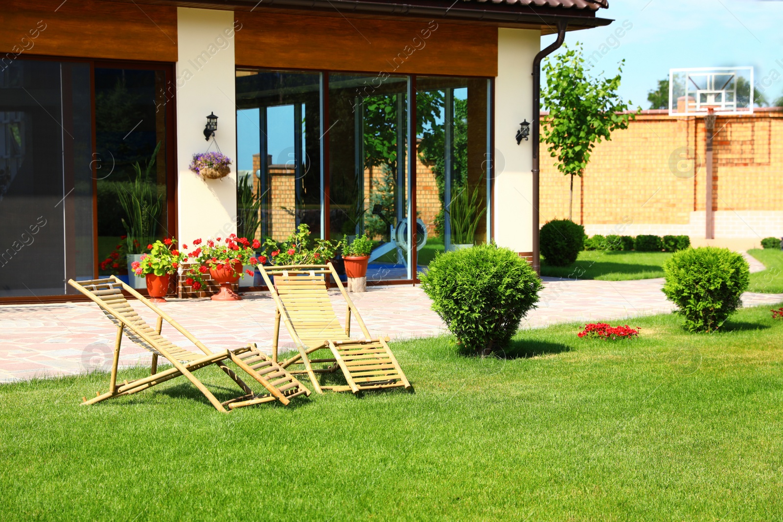 Photo of Wooden deck chairs in beautiful garden on sunny day