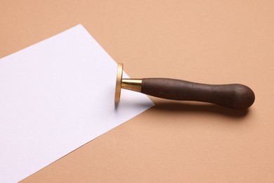 Photo of One stamp tool and sheet of paper on light brown background