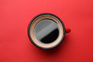 Photo of Fresh coffee in cup on red background, top view