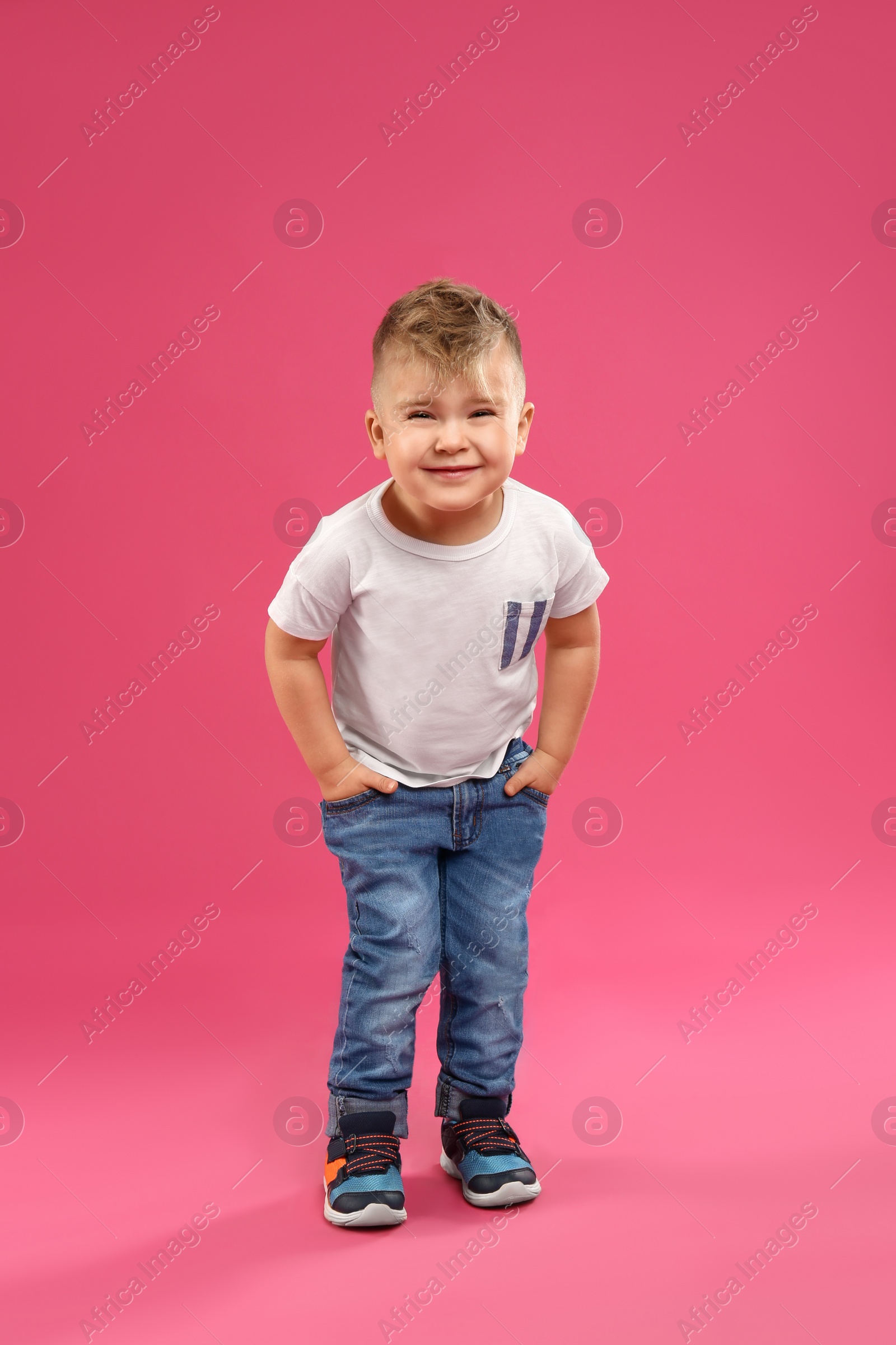 Photo of Cute little boy posing on pink background