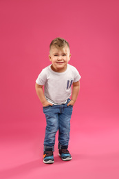 Photo of Cute little boy posing on pink background